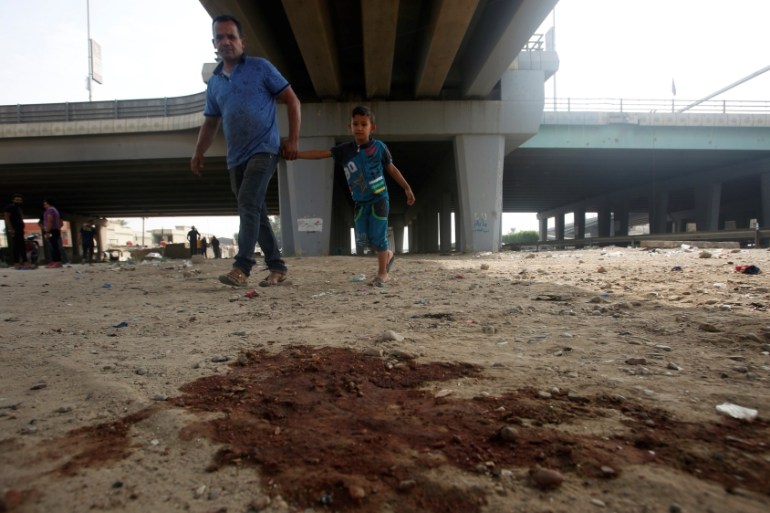 Blood stains are seen on the ground at the site of a suicide bomb attack in Baghdad