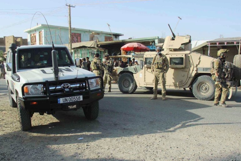 Afghan security forces keep watch in front of their armoured vehicle in Kunduz city