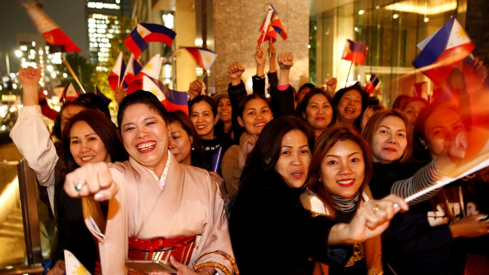 Supporters shout Duterte's name as they wait for his arrival at a hotel in Tokyo on Tuesday [Reuters]