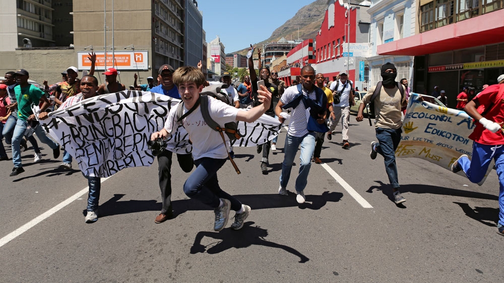 Students protest outside the parliament in Cape Town on Wednesday [Reuters]