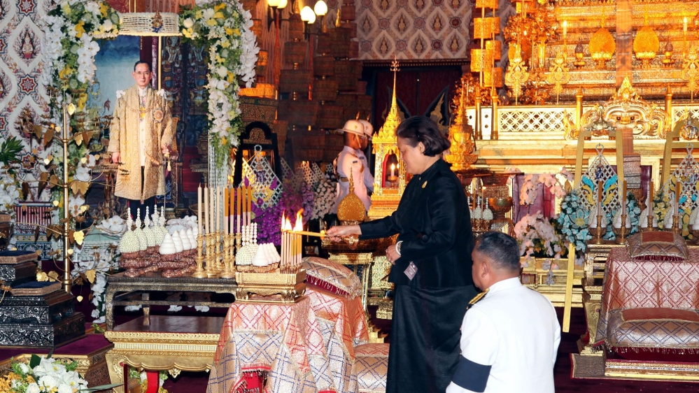 Thai Princess Maha Chakri Sirindhorn lights candles next to portrait of late Thai King Bhumibol on Saturday [EPA]