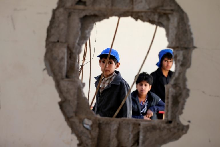 Boys look as they sit in a damaged class of their school which was hit by Saudi-led air strikes last year, as schools open this week in Sanaa, the capital of war-torn Yemen