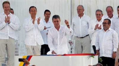 Colombian President Juan Manuel Santos holds a pen made from a bullet before signing an accord with the FARC n in Cartagena, Colombia [Reuters]