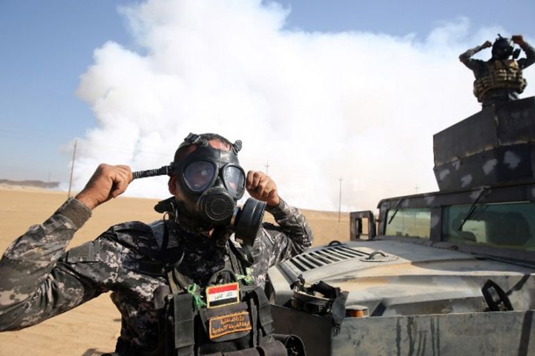 Iraqi forces wear gas masks for protection