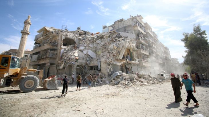 People inspect a damaged site after an air strike Sunday in the rebel-held besieged al-Qaterji neighbourhood of Aleppo