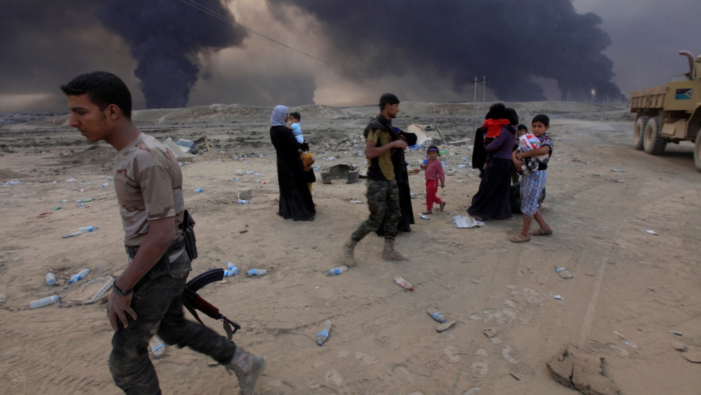 Displaced people who are fleeing from clashes arrive in Qayyarah, during the battle for Mosul [Reuters]