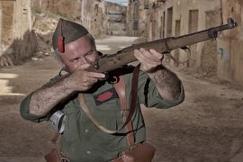 A Spanish civil war re-enactor aiming his rifle [Getty]