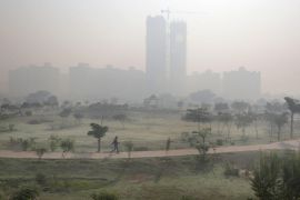 Indian man takes a morning walk in a public garden surrounded by the smog
