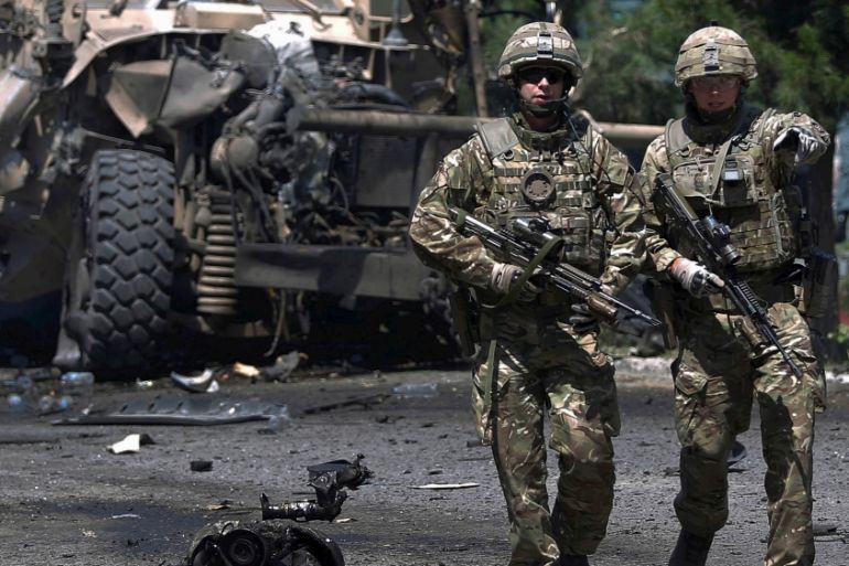 NATO soldiers walk at the site of a suicide bomb attack in Kabul, Afghanistan