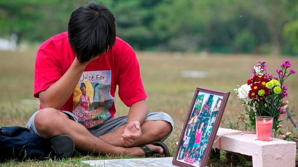 Every week since Jay Ella's daughter was killed by a stray bullet, he's sat by her grave, praying that her killer will be found. His daughter's death led to a public outcry which forced the government to pass a new gun law in 2013 [Steve Chao/Al Jazeera]