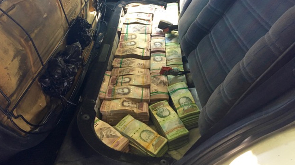 Dicson transports 1.4 million bolivars under the backseat of his car to his home in Cucuta [Anne Bouleanu/Al Jazeera] 