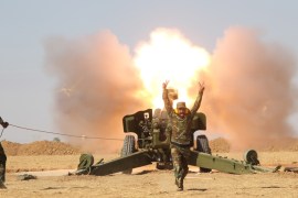 Popular Mobilization Forces (PMF) personnel fire artillery during clashes with Islamic State militants south of Mosul