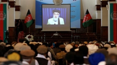A screen showing the broadcast of Hekmatyar during a signing ceremony with the Afghan government at the presidential palace in Kabul, Afghanistan [Reuters]