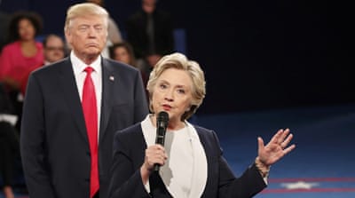 Trump listens as Clinton answers a question during their debate in Missouri [Reuters]