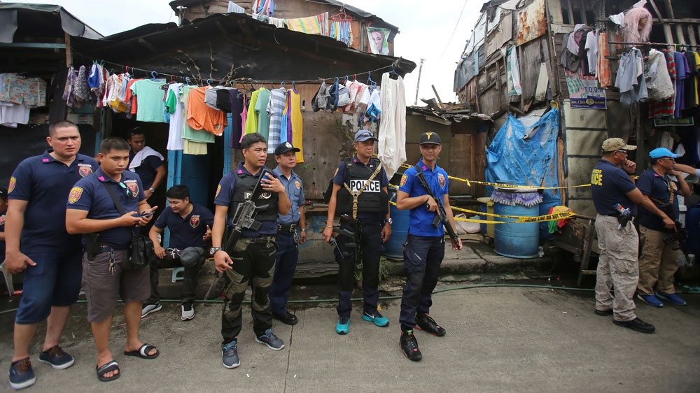 Philippine police stand on guard during a raid in a slum area in Metro Manila [Reuters]