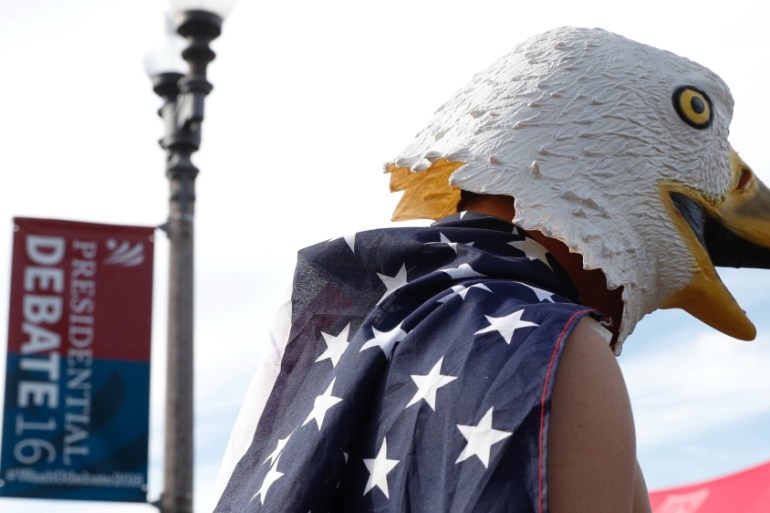 A man wears an eagle mask and is draped in a US flag outside of the event site of the presidential debate between Donald Trump and Hillary Clinton in Missouri, US [REUTERS]