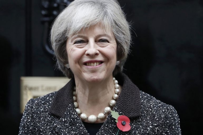 Britain''s Prime Minister Theresa May poses with a poppy after buying it to mark this year''s Poppy Appeal, at Number 10 Downing Street in central London