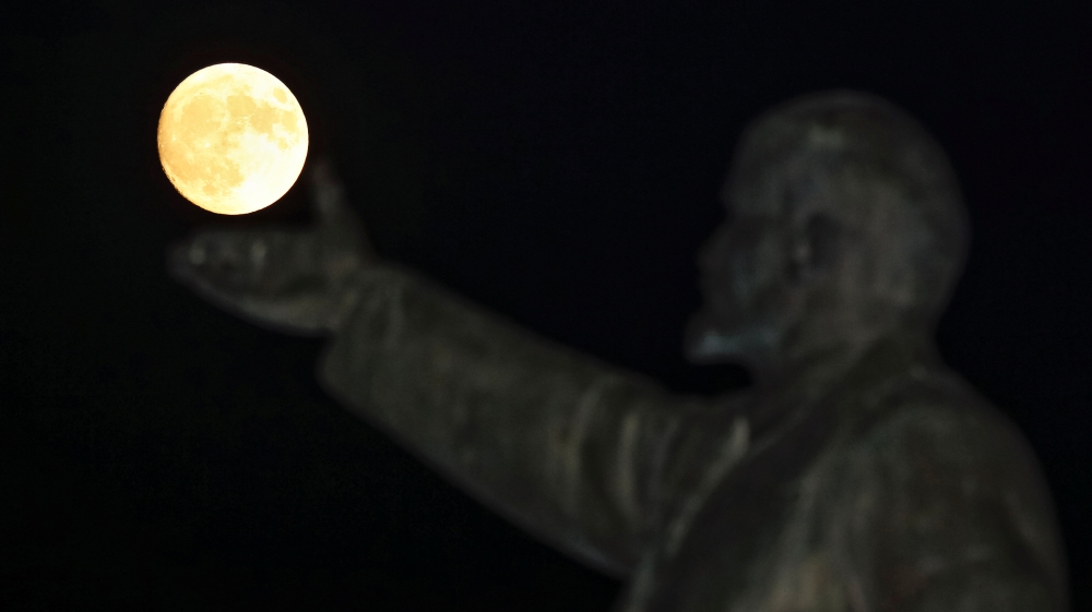 
A full Moon rises behind a statue of Soviet state founder Vladimir Lenin on the eve of the 