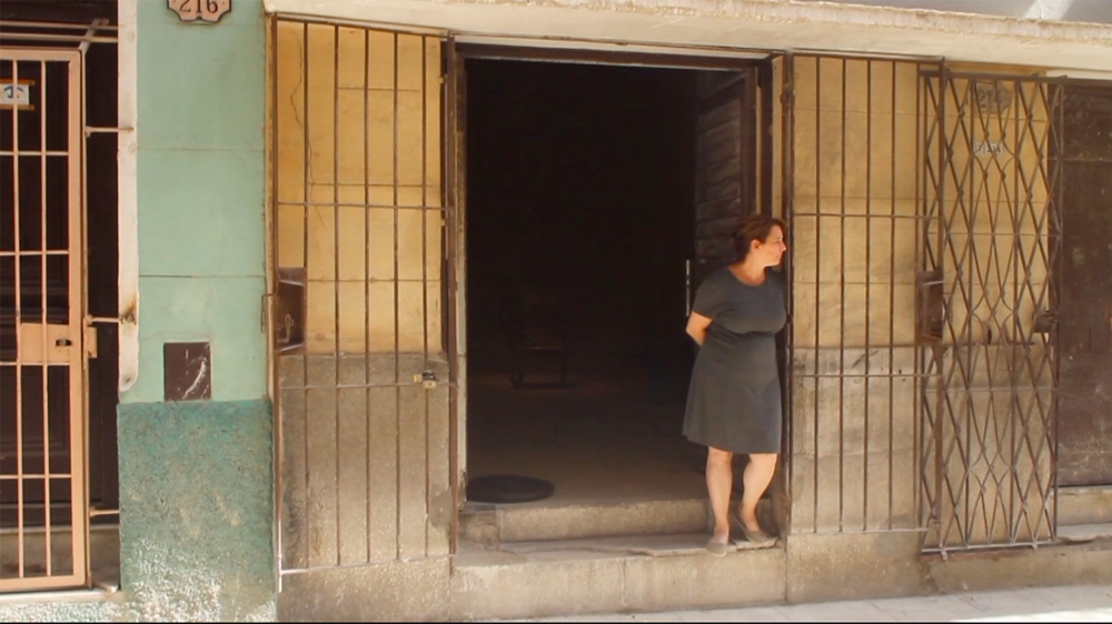 
Bruguera stands in front of her house in Old Havana before her 100-hour open studio reading of Hannah Arendt's The Origins of Totalitarianism [Courtesy of INSTAR]

