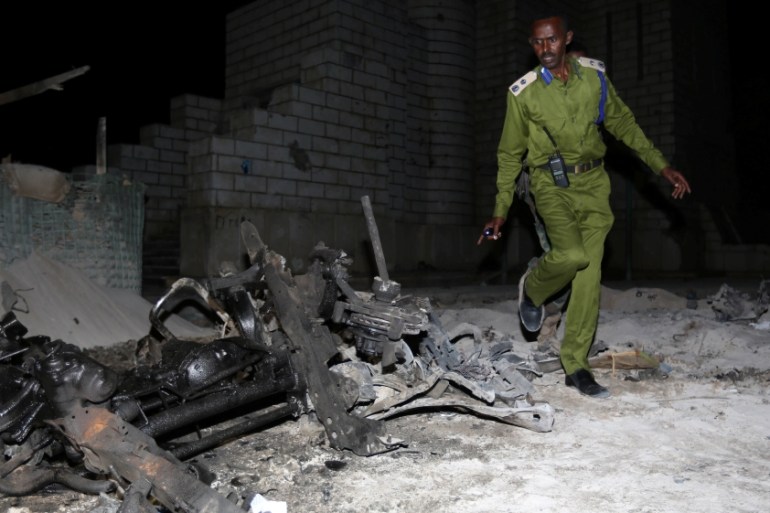 A Somali policeman inspects the scene of a suicide car explosion near the parliament in the capital Mogadishu