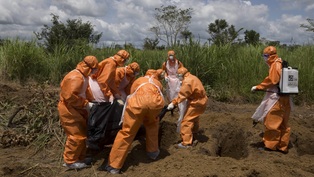 A burial team wearing protective clothes prepares an Ebola virus victim for burial, in Port Loko, Sierra Leone, September 27, 2014 [Christopher Black/Reuters]
