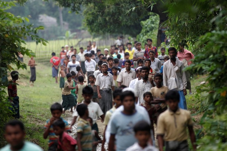 Men walk at a Rohingya village outside Maugndaw in Rakhine state
