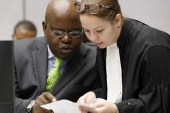  Fidele Babala Wandu, left, of the Democratic Republic of the Congo speaks to a lawyer in the courtroom of the ICC in The Hague, the Netherlands [EPA]