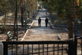 Men walk in a public park in a rebel-held besieged area in Aleppo
