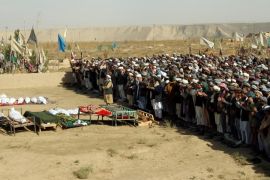 Afghans perform prayers at the funeral for the victims killed by an air strike called in to protect Afghan and U.S. forces during a raid on suspected Taliban militants, in Kunduz