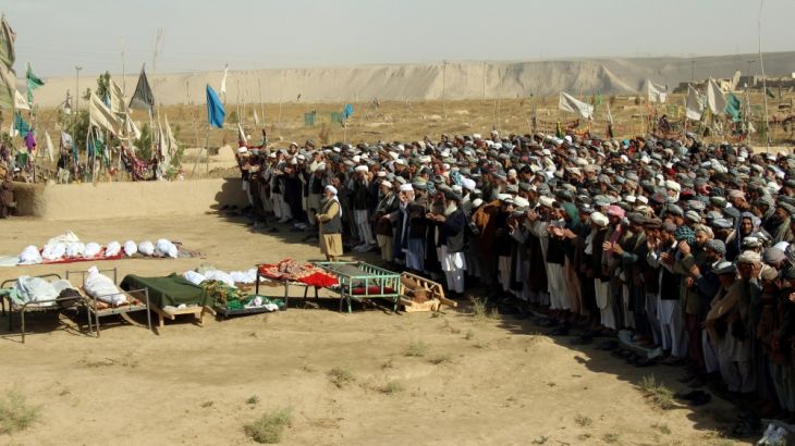 Afghans perform prayers at the funeral for the victims killed by an air strike called in to protect Afghan and U.S. forces during a raid on suspected Taliban militants, in Kunduz