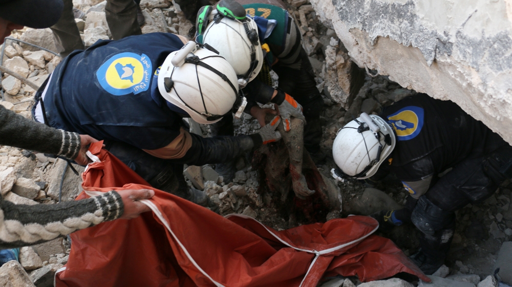 Syrian rescue volunteers pull a body from the rubble of a destroyed building in the Bab al-Nayrab neighbourhood of Aleppo on Saturday [AFP]