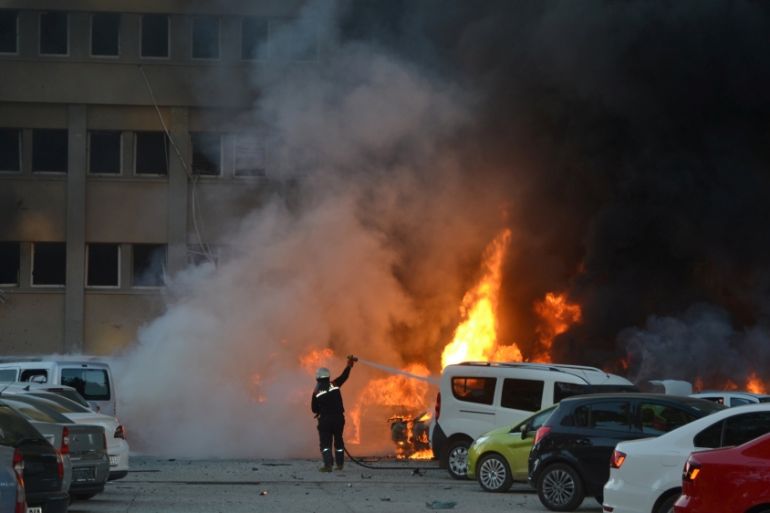 A firefighter tries to extinguish burning vehicles after an explosion outside the governor''s office in the southern city of Adana