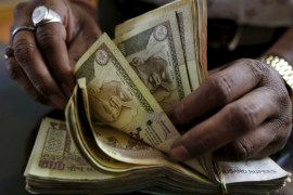 A money lender counts Indian rupee