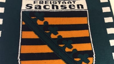 The state flag of Saxony [Sumi Somaskanda/Al Jazeera]