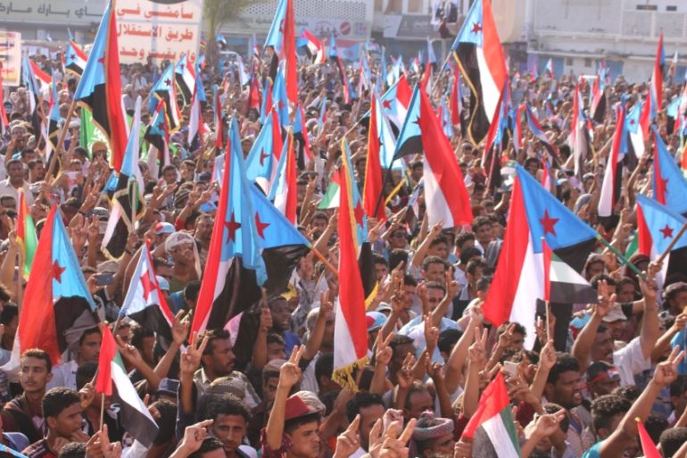 People hold up the flag of former South Yemen during a rally commemorating the 53nd anniversary of the start of South Yemen''s uprising against British rule, in the southern port city of Aden