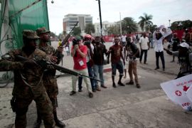 Members of the General Security Unit of the National Palace (USGPN) try to disperse supporters of Fanmi Lavalas political party as they march next to the National Palace of Port-au-Prince, Haiti