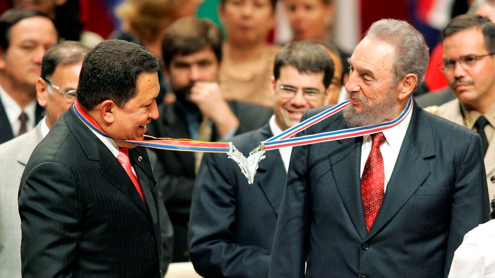 Venezuela's President Hugo Chavez, left, and his Cuban counterpart Fidel Castro joke after joining their medallions, given by medical graduates, at Havana's Karl Marx theatre [Claudia Daut/Reuters] 