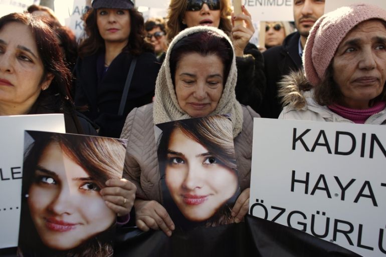 Women walk as they hold pictures of Ozgecan Arslan during a protest against domestic violence, in Istanbul