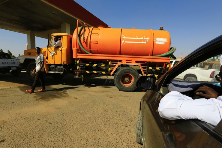 People gather to get fuel at a petrol station in Khartoum