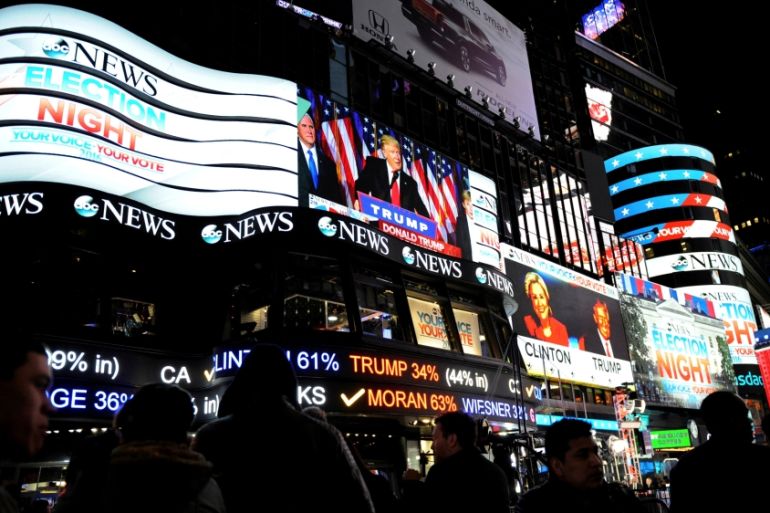 People watch as U.S. president-elect Donald Trump is displayed speaking, in Times Square in New York