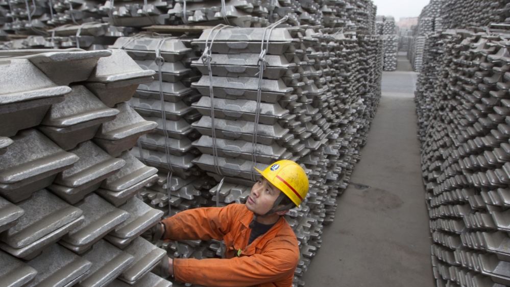 An employee checks aluminium ingots for export at Qingdao Port, in China's Shandong province [REUTERS/Stringer/Files] 