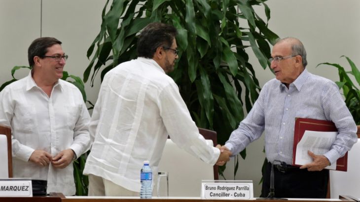 Colombia''s FARC lead negotiator Ivan Marquez and Colombia''s lead government negotiator Humberto de la Calle shake hands while Cuba''s Foreign Minister Bruno Rodriguez looks on,