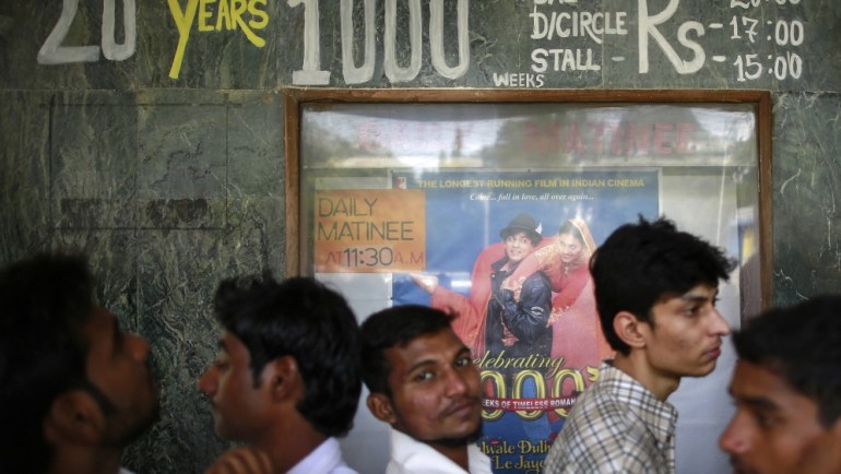 Moviegoers wait for the theater to open to watch Bollywood films 