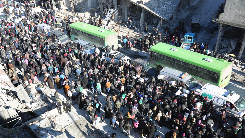 Aleppo residents gather to get onto buses to take them out of the besieged city [Malek al-Shimale/Al Jazeera]