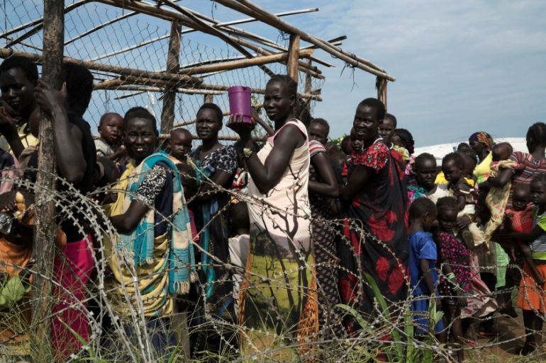 Women and children queue to receive emergency food at the U.N. protection of civilians site 3 hosting about 30,000 people displaced during the recent fighting in Juba