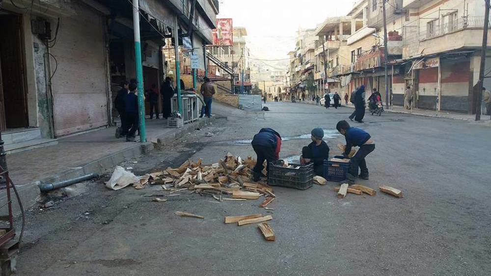 Children breaking wood for fuel in besieged Madaya [Houssam Mohammed/Al Jazeera]
