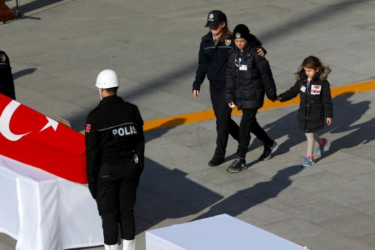 Children of a policeman who died in Saturday''s blasts, walk to their father''s coffin during a ceremony at the police headquarters in Istanbul