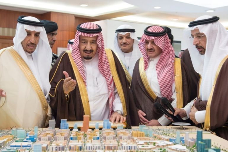 Saudi King Salman looks at models during the inauguration ceremony of several energy projects in Ras Al Khair