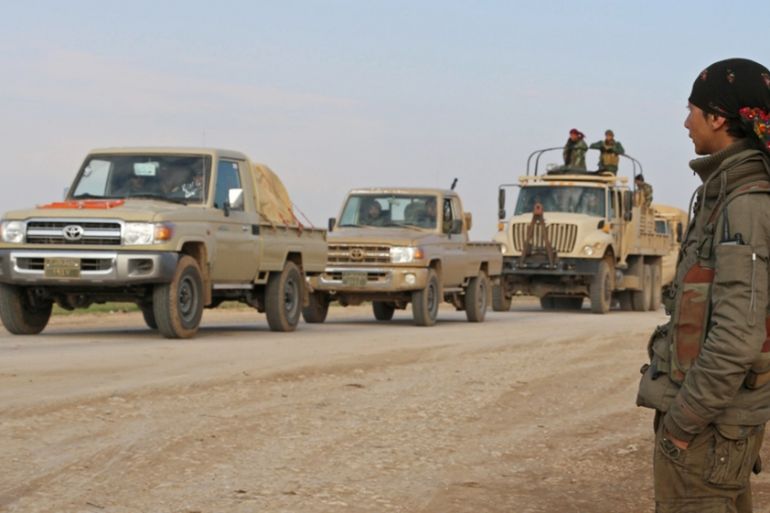 Military vehicles pass by a checkpoint manned by the Kurdish People''s Protection Units and Kurdistan Workers Party fighters, on the highway connecting the towns of Rabia and Snuny