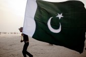 A man walks with a Pakistan National flag, as people gather at Seaview waterfront to celebrate Pakistan's Independence Day on August 14, 2011 in Karachi, Pakistan [Getty]